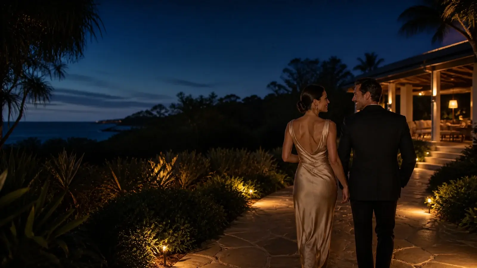Elegant couple walking through an Australian coastal retreat at blue hour